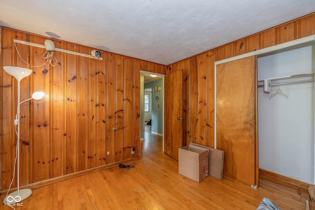 2445 S Bolton Ave, Indianapolis, IN 46203 - unfurnished bedroom with a closet, wooden walls, wood finished floors, and baseboards
