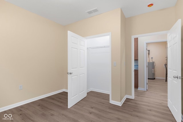 232 E Main St, Austin, IN 47102 - unfurnished bedroom featuring water heater, wood finished floors, baseboards, and a closet