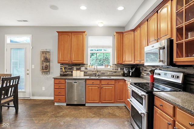 7312 Drum Castle Ct, Indianapolis, IN 46259 - kitchen with stainless steel appliances, a sink, backsplash, glass insert cabinets, and recessed lighting