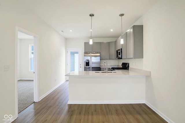 3927 Wren Dr, Brownsburg, IN 46112 - kitchen featuring appliances with stainless steel finishes, gray cabinetry, a sink, wood finished floors, and a peninsula