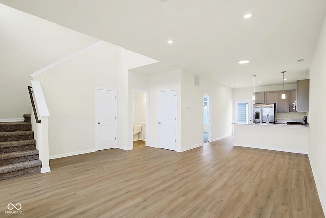 3927 Wren Dr, Brownsburg, IN 46112 - unfurnished living room featuring stairs, light wood finished floors, baseboards, and recessed lighting