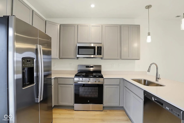 3927 Wren Dr, Brownsburg, IN 46112 - kitchen featuring appliances with stainless steel finishes, a sink, gray cabinets, light countertops, and light wood finished floors