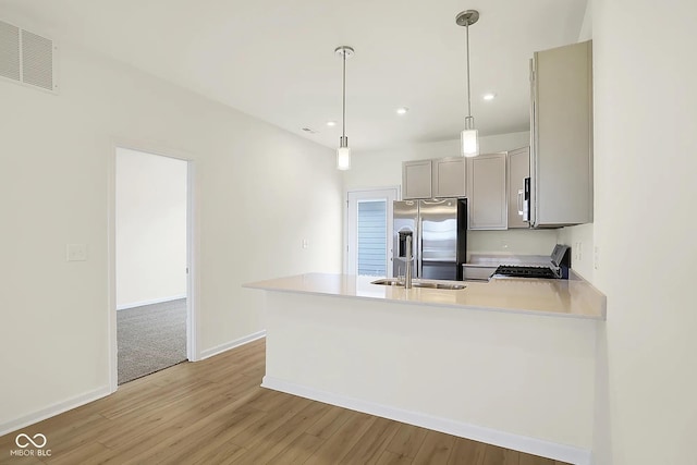 3927 Wren Dr, Brownsburg, IN 46112 - kitchen featuring stainless steel appliances, gray cabinets, light wood-style flooring, light countertops, and a peninsula