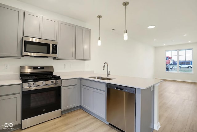 3927 Wren Dr, Brownsburg, IN 46112 - kitchen with stainless steel appliances, a sink, gray cabinets, a peninsula, and light wood finished floors