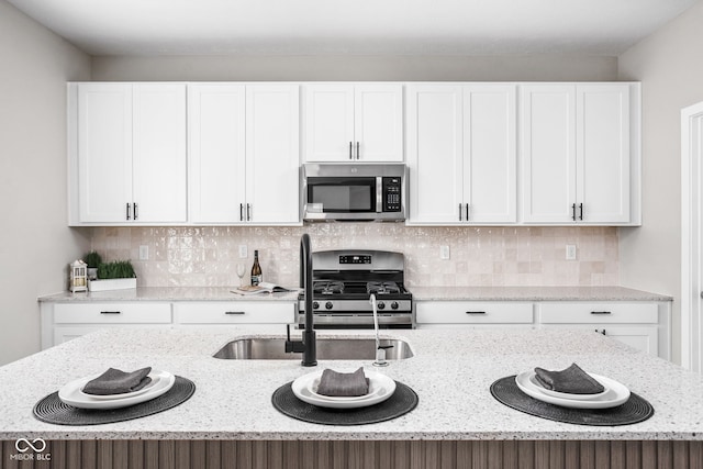 11588 Brooks Farm Blvd, Noblesville, IN 46060 - kitchen with appliances with stainless steel finishes, white cabinets, light stone countertops, and backsplash