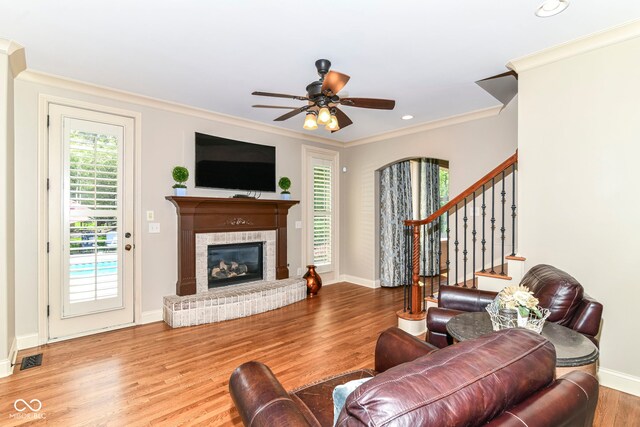 13909 Waterway Blvd, Fishers, IN 46040 - living area with crown molding, wood finished floors, a brick fireplace, baseboards, and stairs