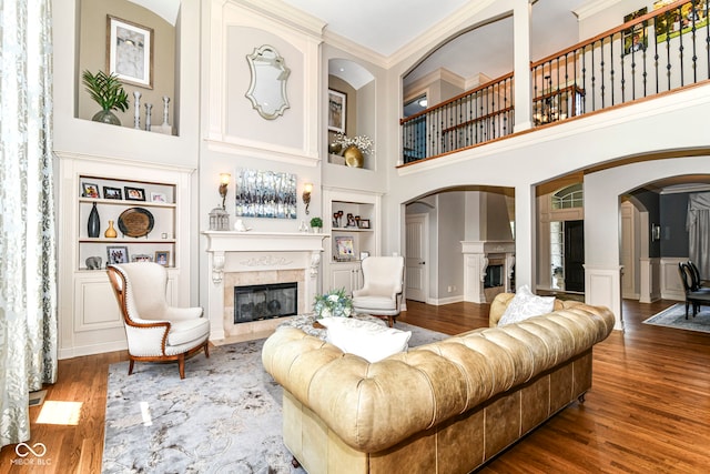 13909 Waterway Blvd, Fishers, IN 46040 - living room with a premium fireplace, built in shelves, arched walkways, wood finished floors, and a high ceiling