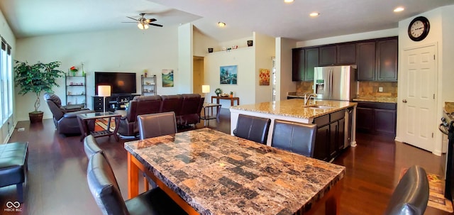 6110 Pelican Ln, Columbus, IN 47201 - kitchen with a kitchen island with sink, a sink, stainless steel fridge with ice dispenser, dark wood-style floors, and vaulted ceiling