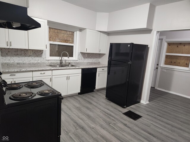 323-325 N Gladstone Ave, Indianapolis, IN 46201 - kitchen with black appliances, under cabinet range hood, a sink, tasteful backsplash, and white cabinetry