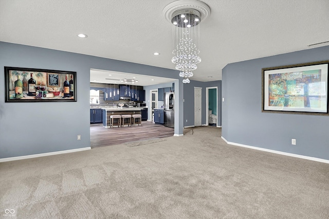 9001 Harrison Run Ct, Indianapolis, IN 46256 - unfurnished living room with light colored carpet, baseboards, recessed lighting, a textured ceiling, and a chandelier