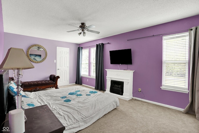 9001 Harrison Run Ct, Indianapolis, IN 46256 - carpeted bedroom featuring a textured ceiling, baseboards, ceiling fan, and a fireplace with raised hearth