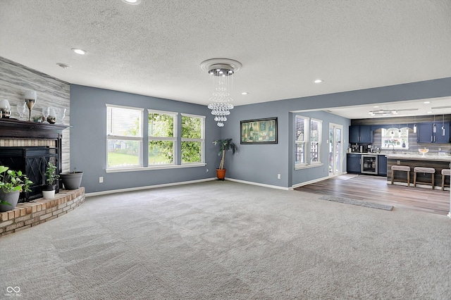 9001 Harrison Run Ct, Indianapolis, IN 46256 - unfurnished living room with light colored carpet, baseboards, a fireplace, recessed lighting, and a textured ceiling
