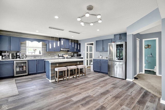 9001 Harrison Run Ct, Indianapolis, IN 46256 - kitchen featuring smart refrigerator, wine cooler, a breakfast bar, light countertops, and blue cabinetry