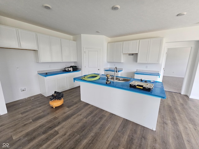 2339 Pine Valley Dr, Plainfield, IN 46168 - kitchen featuring dark wood-type flooring, white cabinetry, a center island with sink, and a textured ceiling
