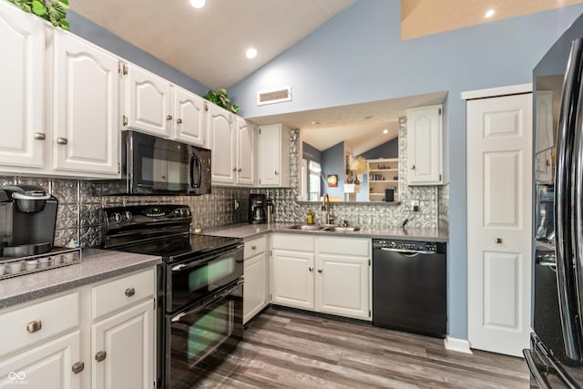 3403 Island Way, Indianapolis, IN 46214 - kitchen with black appliances, a sink, vaulted ceiling, decorative backsplash, and white cabinetry