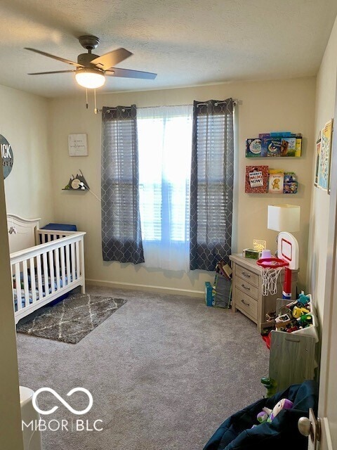 1349 Sunset Blvd, Avon, IN 46123 - carpeted bedroom with a nursery area, a ceiling fan, and baseboards