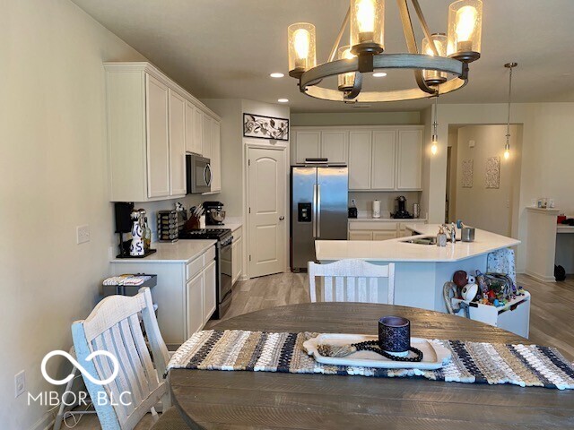 1349 Sunset Blvd, Avon, IN 46123 - kitchen featuring stainless steel refrigerator with ice dispenser, black gas stove, a chandelier, white cabinetry, and recessed lighting