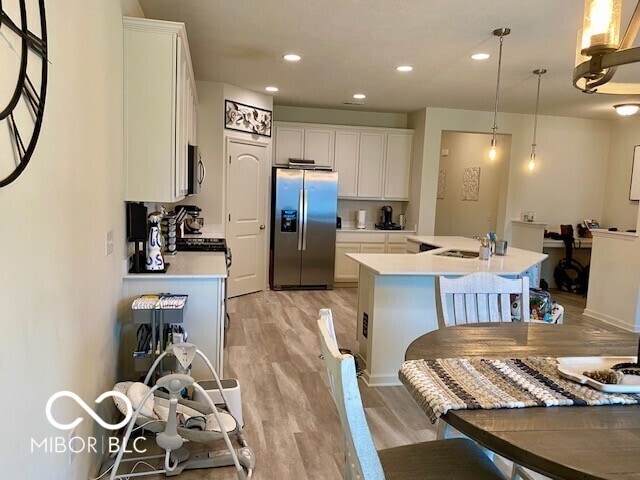1349 Sunset Blvd, Avon, IN 46123 - kitchen featuring appliances with stainless steel finishes, light wood finished floors, a sink, light countertops, and white cabinetry