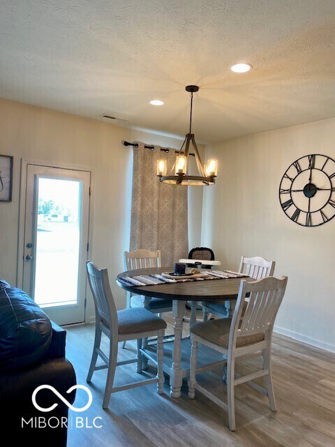 1349 Sunset Blvd, Avon, IN 46123 - dining area with a chandelier, wood finished floors, a textured ceiling, recessed lighting, and baseboards