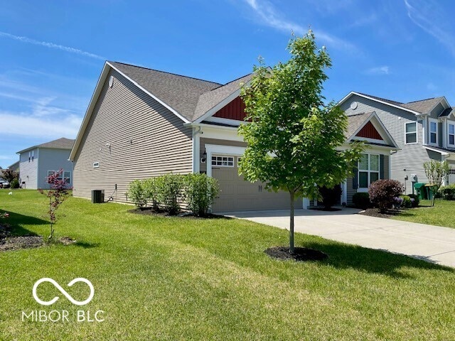 1349 Sunset Blvd, Avon, IN 46123 - view of home's exterior featuring concrete driveway, a yard, central air condition unit, an attached garage, and board and batten siding