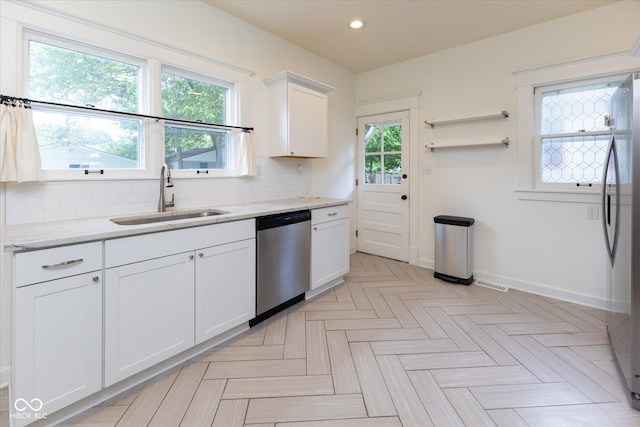 1311 N Oakland Ave, Indianapolis, IN 46201 - kitchen featuring stainless steel appliances, a sink, baseboards, white cabinetry, and tasteful backsplash