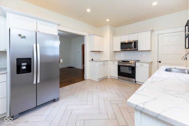 1311 N Oakland Ave, Indianapolis, IN 46201 - kitchen with appliances with stainless steel finishes, a sink, white cabinetry, backsplash, and recessed lighting