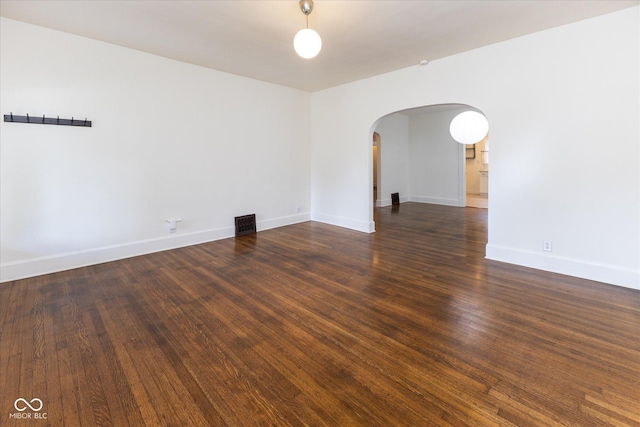 1311 N Oakland Ave, Indianapolis, IN 46201 - unfurnished room with arched walkways, baseboards, and wood finished floors