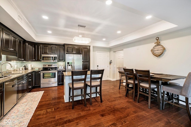 20971 Shoreline Ct Unit 201, Noblesville, IN 46062 - kitchen featuring appliances with stainless steel finishes, light stone counters, ornamental molding, a raised ceiling, and recessed lighting