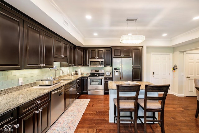20971 Shoreline Ct Unit 201, Noblesville, IN 46062 - kitchen with stainless steel appliances, light stone counters, ornamental molding, a kitchen breakfast bar, and dark wood-type flooring