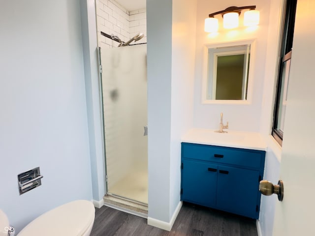 5130 Navajo Ct, Columbus, IN 47203 - full bathroom featuring wood finished floors, toilet, vanity, a shower stall, and baseboards