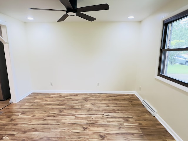 5130 Navajo Ct, Columbus, IN 47203 - spare room featuring wood finished floors, a ceiling fan, a baseboard radiator, recessed lighting, and baseboards