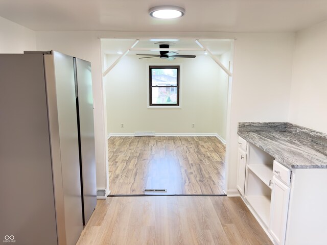 5130 Navajo Ct, Columbus, IN 47203 - unfurnished dining area with light wood-style flooring, a ceiling fan, and baseboards