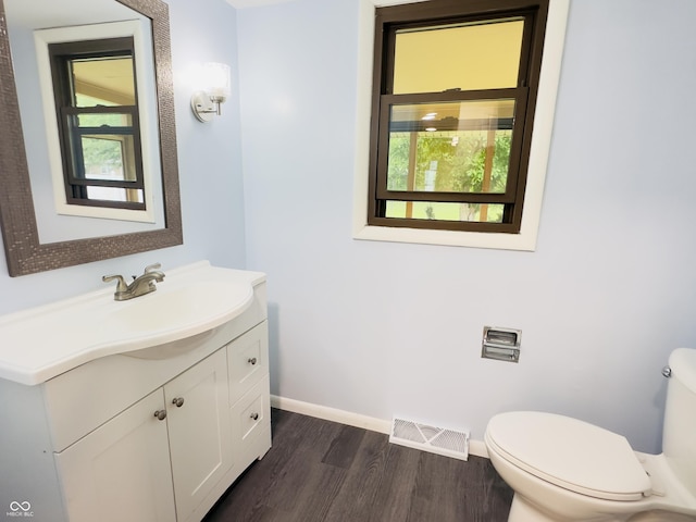 5130 Navajo Ct, Columbus, IN 47203 - bathroom with toilet, vanity, wood finished floors, and baseboards