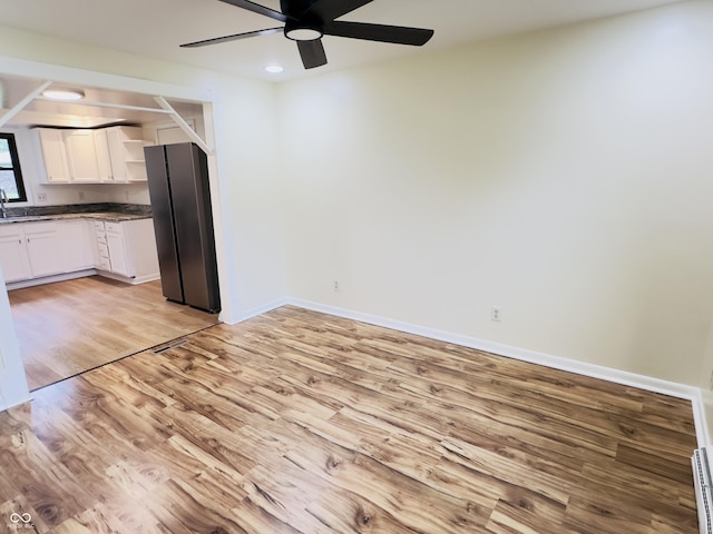 5130 Navajo Ct, Columbus, IN 47203 - unfurnished dining area featuring light wood-style floors, a ceiling fan, a sink, baseboards, and a baseboard heating unit