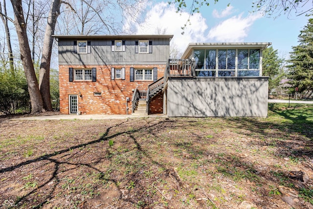1920 E Wexley Rd, Bloomington, IN 47401 - rear view of property with stairs, a sunroom, brick siding, board and batten siding, and a wooden deck