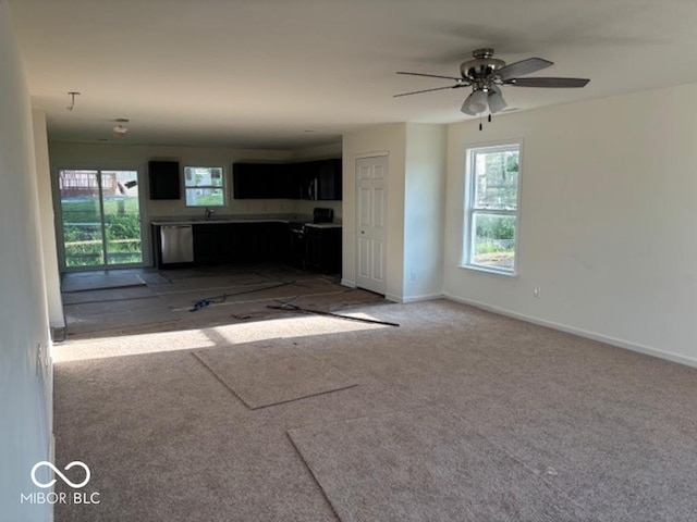 3805 Windstar Way, Columbus, IN 47203 - unfurnished living room featuring light colored carpet, a sink, a ceiling fan, and baseboards