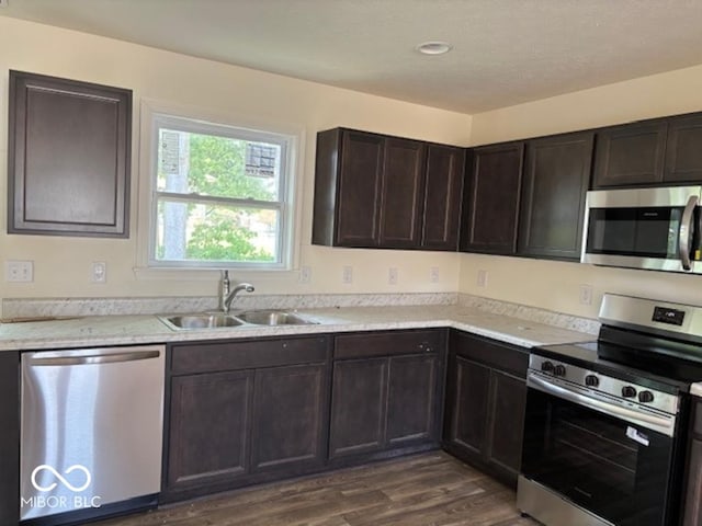 3805 Windstar Way, Columbus, IN 47203 - kitchen featuring appliances with stainless steel finishes, a sink, dark wood-style flooring, dark brown cabinets, and light countertops