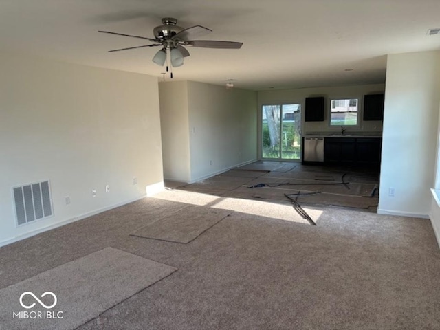 3805 Windstar Way, Columbus, IN 47203 - unfurnished living room with a ceiling fan, baseboards, carpet floors, and a sink