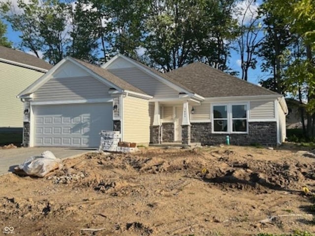 3805 Windstar Way, Columbus, IN 47203 - craftsman-style home with an attached garage, driveway, and stone siding