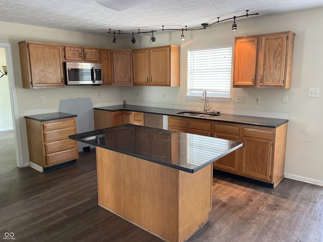 3916 Jekyll Ct, Indianapolis, IN 46237 - kitchen featuring stainless steel microwave, a sink, dark wood-style flooring, and dark countertops