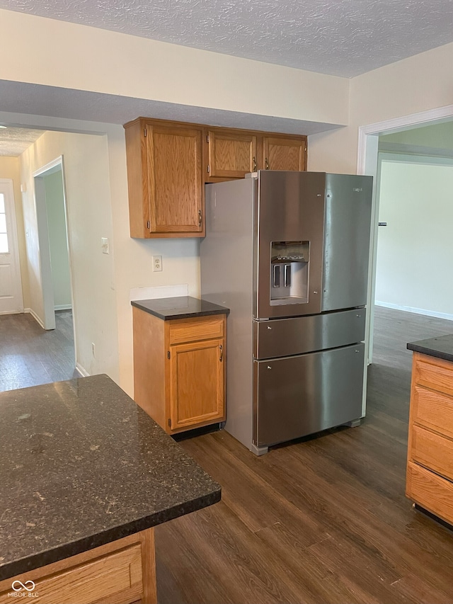 3916 Jekyll Ct, Indianapolis, IN 46237 - kitchen with stainless steel fridge with ice dispenser, dark wood finished floors, brown cabinets, a textured ceiling, and dark stone counters