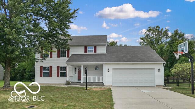 3916 Jekyll Ct, Indianapolis, IN 46237 - view of front of house with covered porch, an attached garage, a front lawn, and concrete driveway