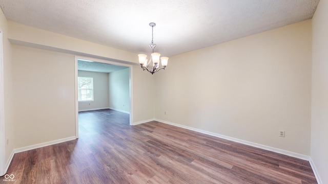 3916 Jekyll Ct, Indianapolis, IN 46237 - empty room with dark wood-style floors, a chandelier, and baseboards