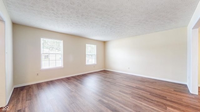 3916 Jekyll Ct, Indianapolis, IN 46237 - empty room featuring dark wood-style floors, baseboards, and a textured ceiling