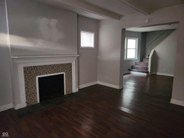 2707-2709 N College Ave, Indianapolis, IN 46205 - unfurnished living room featuring wood finished floors, beam ceiling, stairs, a tiled fireplace, and baseboards