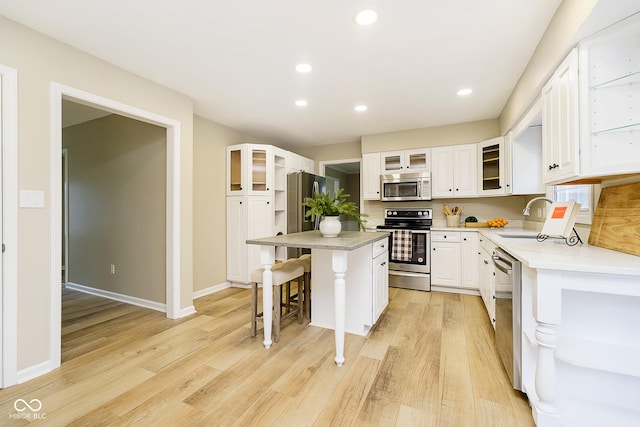10245 Briar Creek Ln, Carmel, IN 46033 - kitchen with appliances with stainless steel finishes, a sink, a center island, light wood-style floors, and a breakfast bar
