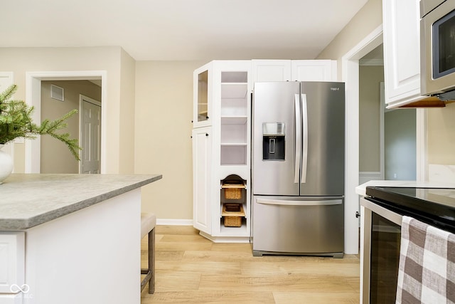 10245 Briar Creek Ln, Carmel, IN 46033 - kitchen with stainless steel appliances, light wood-style floors, white cabinetry, light countertops, and a breakfast bar