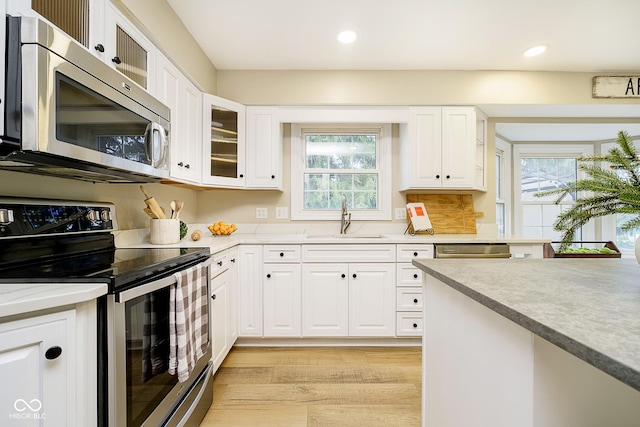 10245 Briar Creek Ln, Carmel, IN 46033 - kitchen featuring appliances with stainless steel finishes, a sink, light wood-type flooring, recessed lighting, and white cabinetry