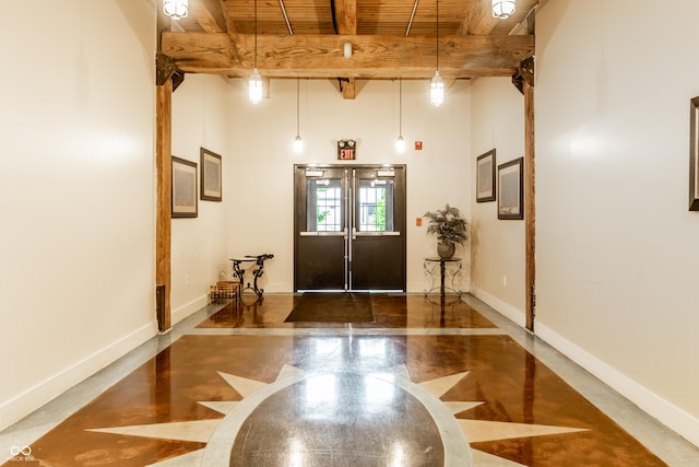 55 S Harding St Unit 308, Indianapolis, IN 46222 - entrance foyer featuring wood ceiling with exposed beams, baseboards, a high ceiling, and inlaid floor details