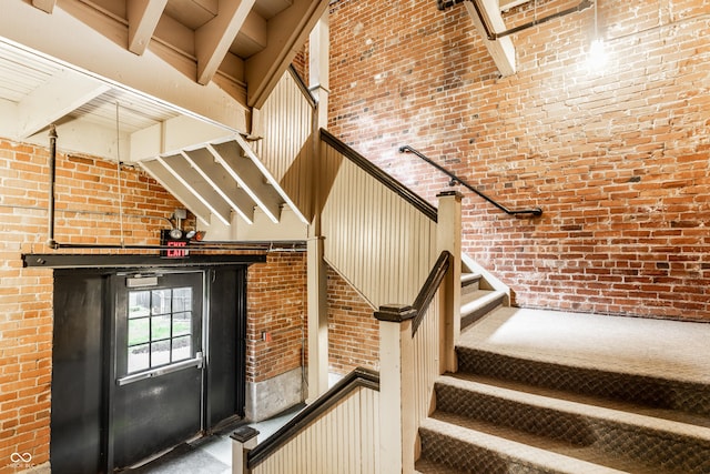 55 S Harding St Unit 308, Indianapolis, IN 46222 - stairs featuring brick wall, beamed ceiling, and a high ceiling